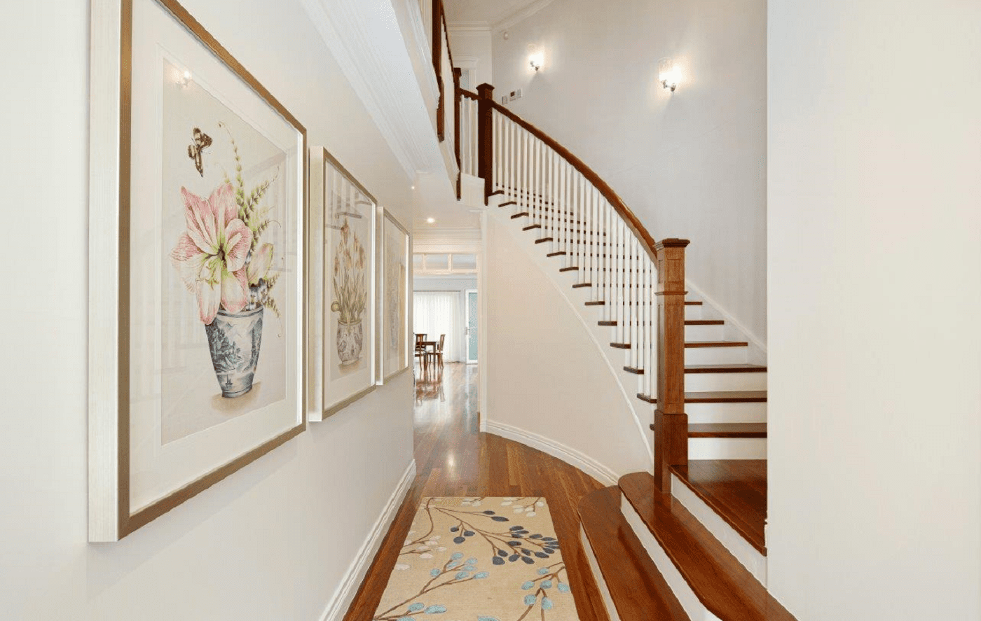 Curved hardwood staircase in elegant Kedron hallway