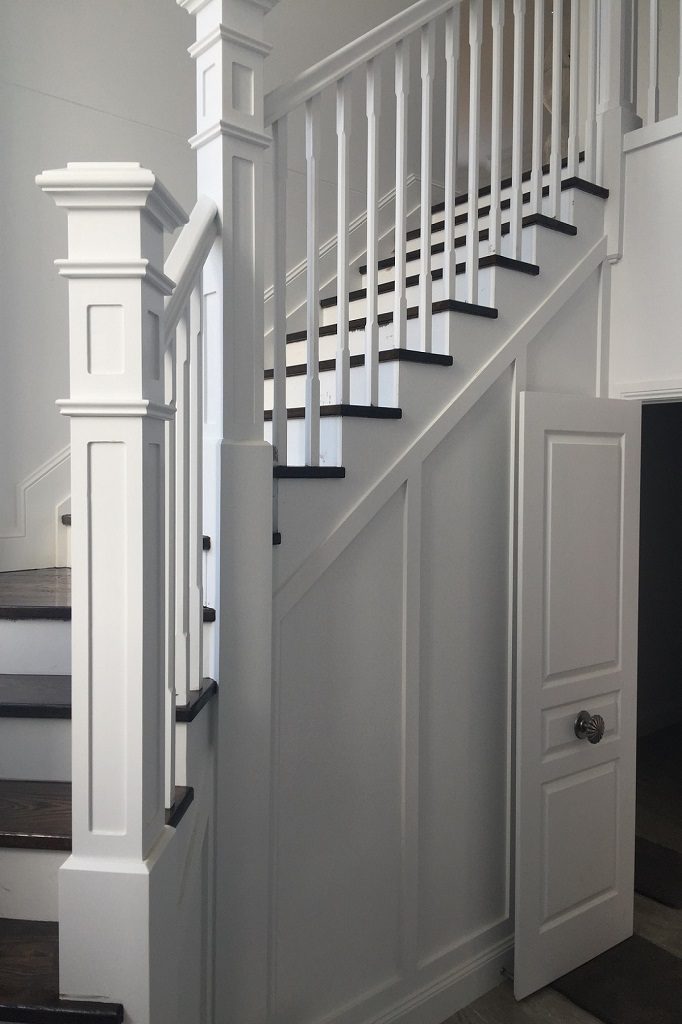 Hampton painted staircase with newel post and under-stair storage in Eatons Hill home