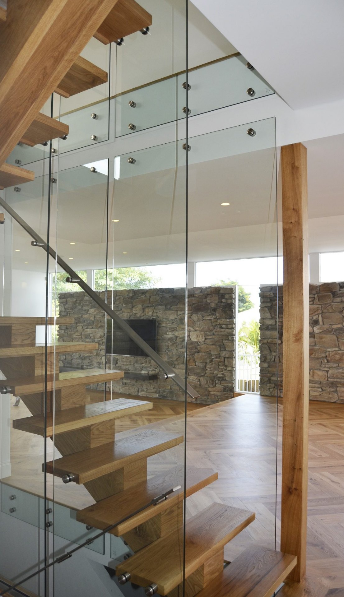 Modern floating timber staircase with glass balustrade in Scarborough home